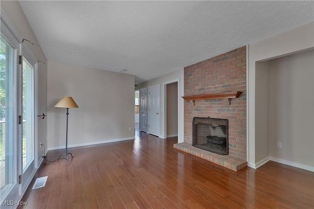 233 Robbies Run, Cortland, OH 44410 - unfurnished living room with a textured ceiling, wood finished floors, and a fireplace