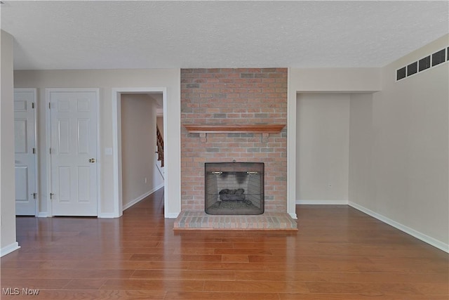 233 Robbies Run, Cortland, OH 44410 - unfurnished living room with a textured ceiling, wood finished floors, and a fireplace