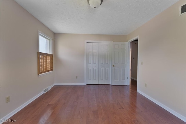 233 Robbies Run, Cortland, OH 44410 - unfurnished bedroom with wood finished floors, a textured ceiling, and a closet