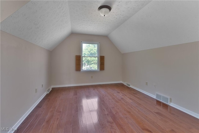 233 Robbies Run, Cortland, OH 44410 - additional living space featuring wood-type flooring, a textured ceiling, and lofted ceiling