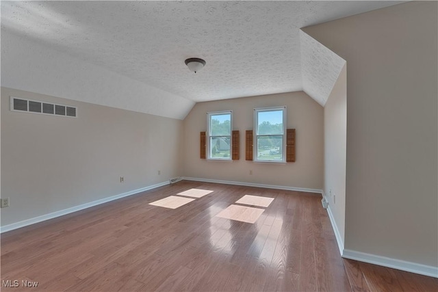 233 Robbies Run, Cortland, OH 44410 - bonus room with a textured ceiling, lofted ceiling, and wood finished floors