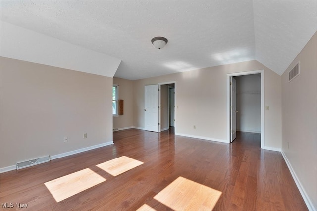 233 Robbies Run, Cortland, OH 44410 - spare room with wood finished floors, lofted ceiling, and a textured ceiling