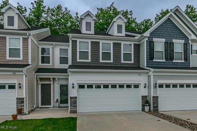 864 Woodside Dr, Westlake, OH 44145 - townhome / multi-family property with an attached garage, stone siding, and driveway