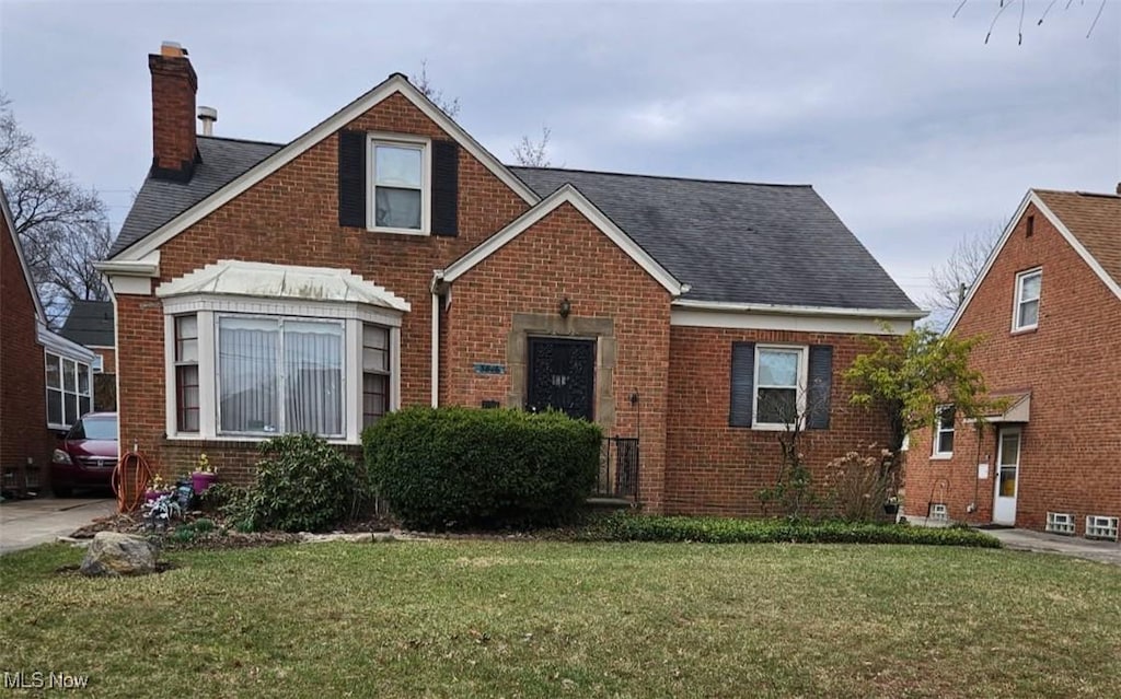 3846 Warrendale Rd, South Euclid, OH 44118 - view of front facade with brick siding, a chimney, and a front yard