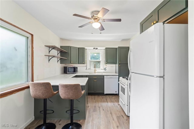 302 Bender Ave, Akron, OH 44312 - kitchen featuring white appliances, open shelves, a peninsula, light wood-style floors, and a breakfast bar