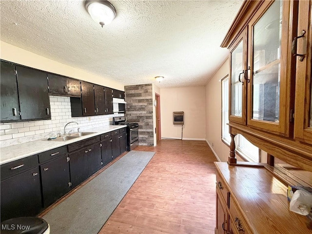 5048 Grove Ave, Lorain, OH 44055 - kitchen with stainless steel range with gas cooktop, a textured ceiling, heating unit, light wood finished floors, and white microwave