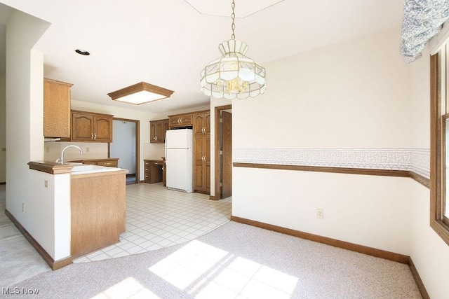 215 Bailey Ct, Doylestown, OH 44230 - kitchen with freestanding refrigerator, pendant lighting, and brown cabinets