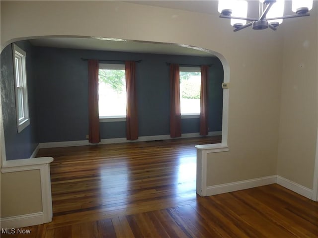 6069 Hyde St, Mentor, OH 44060 - empty room with arched walkways, a chandelier, and wood finished floors