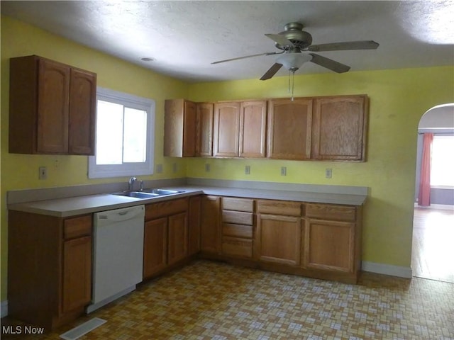 6069 Hyde St, Mentor, OH 44060 - kitchen with white dishwasher, ceiling fan, light countertops, and brown cabinetry