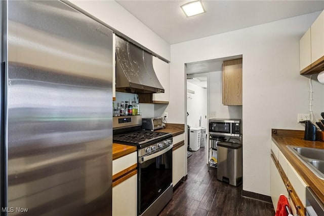 8080 Harbor Crk Unit 503, Mentor On The Lake, OH 44060 - kitchen featuring appliances with stainless steel finishes, wall chimney exhaust hood, wooden counters, dark wood finished floors, and white cabinets