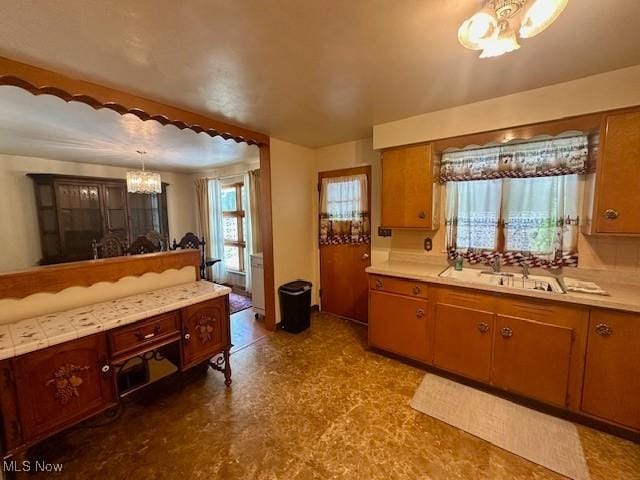 211 Donnell St, Weirton, WV 26062 - kitchen featuring a chandelier, light countertops, tile patterned floors, and brown cabinetry