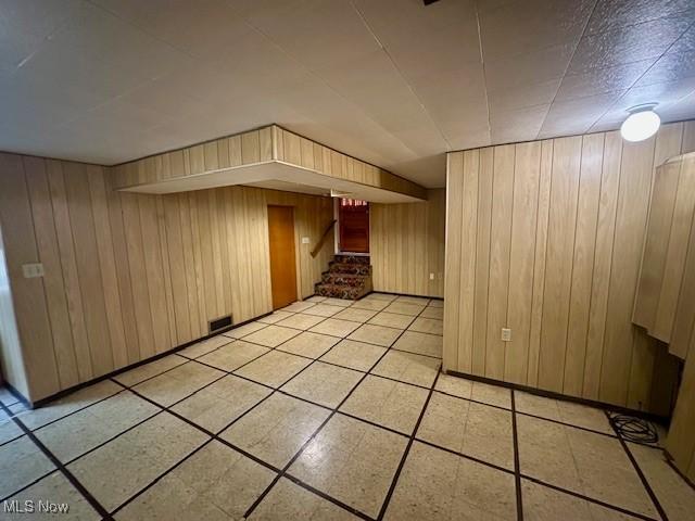 211 Donnell St, Weirton, WV 26062 - bonus room featuring wood walls, stairway, and light tile patterned flooring