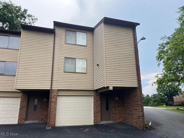 2157 Penguin Ave, Akron, OH 44319 - townhome / multi-family property featuring brick siding, an attached garage, and driveway