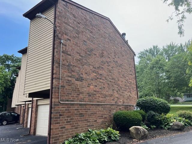 2157 Penguin Ave, Akron, OH 44319 - view of side of property with an attached garage, brick siding, and asphalt driveway