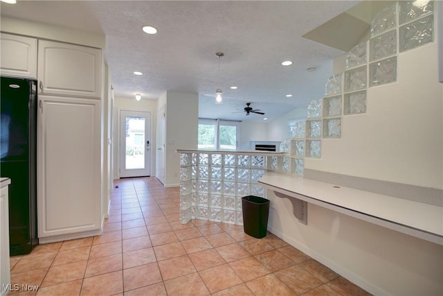 181 Seminary St, Berea, OH 44017 - kitchen featuring freestanding refrigerator, white cabinetry, ceiling fan, a fireplace, and light tile patterned floors