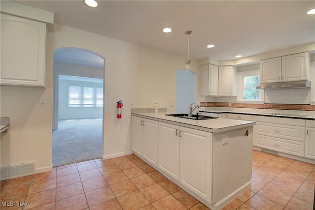 181 Seminary St, Berea, OH 44017 - kitchen featuring arched walkways, a peninsula, white cabinetry, light colored carpet, and recessed lighting