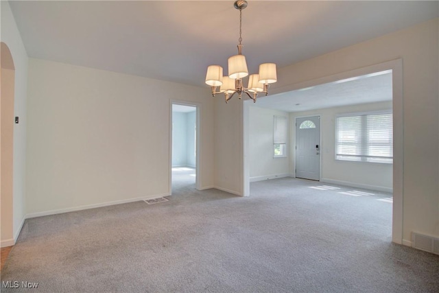 181 Seminary St, Berea, OH 44017 - carpeted empty room with a chandelier and arched walkways