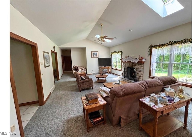 611 Wainwright Rd SE, New Philadelphia, OH 44663 - living room featuring light carpet, plenty of natural light, lofted ceiling, a stone fireplace, and a ceiling fan