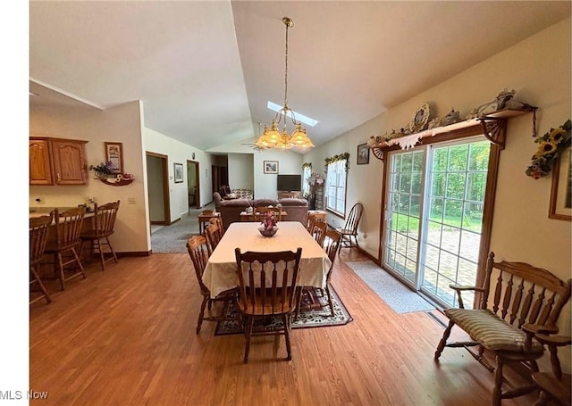 611 Wainwright Rd SE, New Philadelphia, OH 44663 - dining space featuring light wood-style flooring, lofted ceiling, and a chandelier