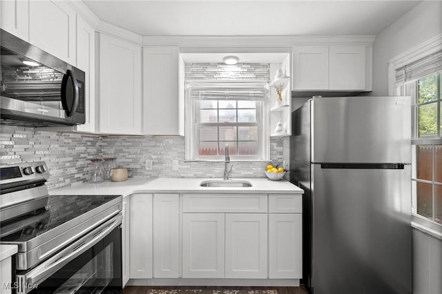 2324 Scholl Rd, University Heights, OH 44118 - kitchen featuring stainless steel appliances, white cabinets, tasteful backsplash, and light countertops