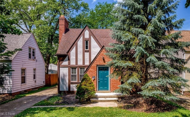 2324 Scholl Rd, University Heights, OH 44118 - tudor home featuring a chimney, roof with shingles, and stucco siding