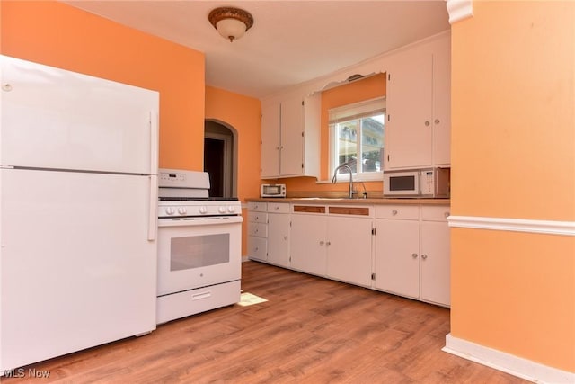 1212 State Route 7 NE, Brookfield, OH 44403 - kitchen featuring white appliances, white cabinetry, light wood-style flooring, and arched walkways