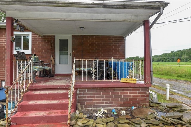 1212 State Route 7 NE, Brookfield, OH 44403 - doorway to property featuring covered porch and brick siding