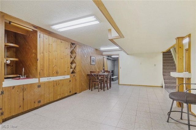 2970 Meadow Ln, Youngstown, OH 44511 - dining area featuring wood walls, stairway, and a textured ceiling