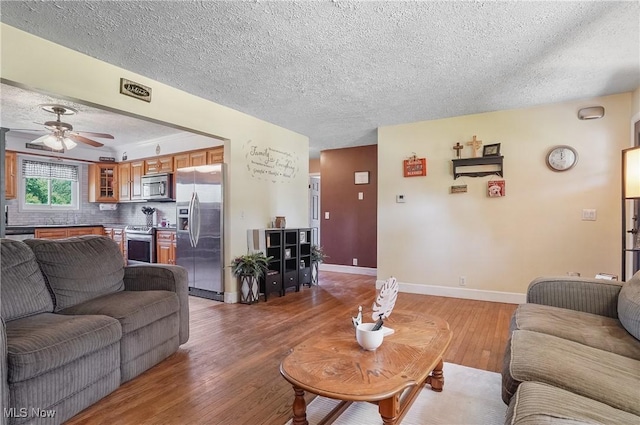 13774 Smith Goshen Rd, Beloit, OH 44609 - living room with a textured ceiling, light wood finished floors, and a ceiling fan