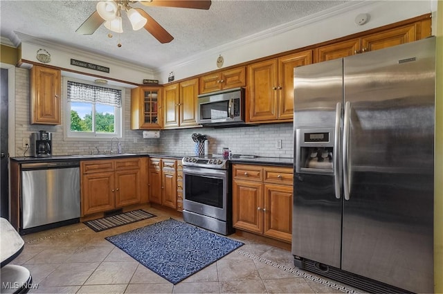 13774 Smith Goshen Rd, Beloit, OH 44609 - kitchen with appliances with stainless steel finishes, brown cabinets, crown molding, dark countertops, and tasteful backsplash
