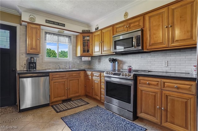 13774 Smith Goshen Rd, Beloit, OH 44609 - kitchen with appliances with stainless steel finishes, brown cabinetry, light tile patterned flooring, tasteful backsplash, and crown molding