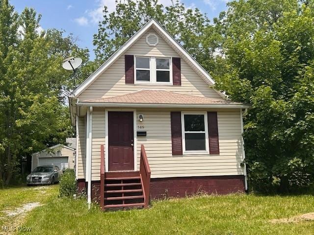 589 Corice St, Akron, OH 44311 - view of front of house with entry steps, a garage, and a front lawn