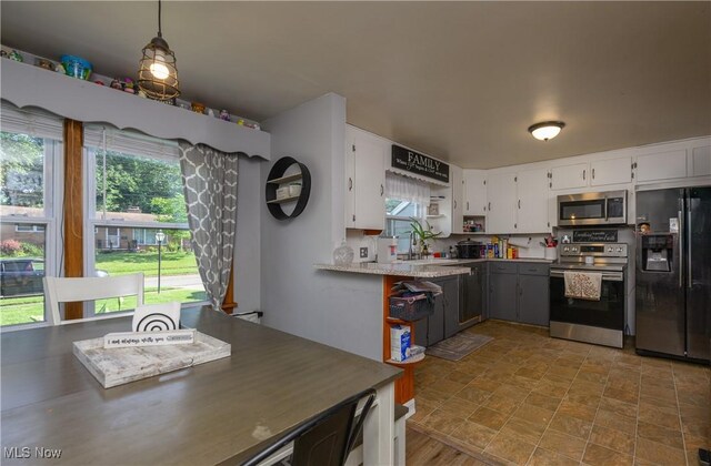 1819 49th St NW, Canton, OH 44709 - kitchen with stainless steel appliances, white cabinetry, and light countertops