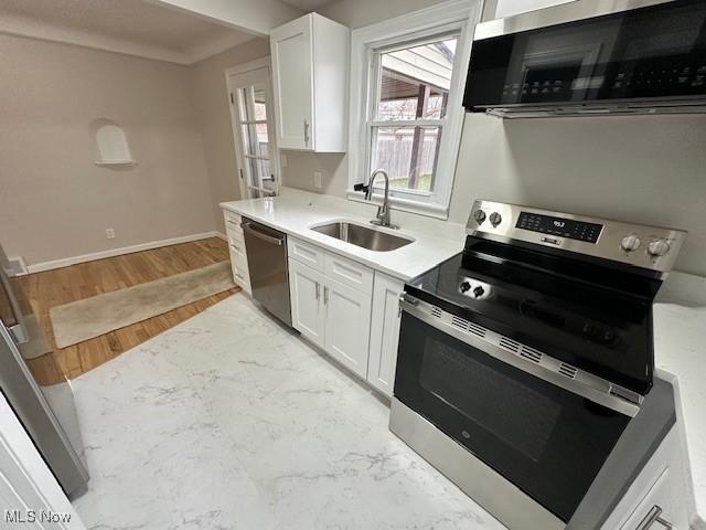4206 Verona Rd, South Euclid, OH 44121 - kitchen with appliances with stainless steel finishes, white cabinetry, light countertops, and light wood-type flooring
