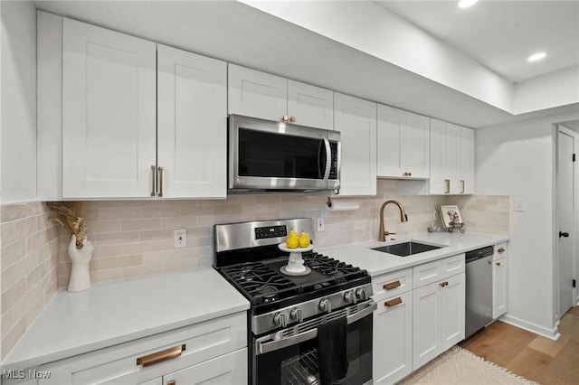 26749 Lake Of The Falls Blvd, Olmsted Falls, OH 44138 - kitchen featuring stainless steel appliances, white cabinets, light wood-style flooring, light countertops, and recessed lighting