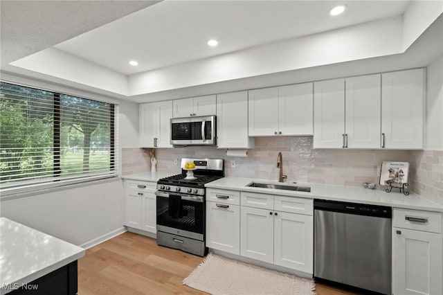 26749 Lake Of The Falls Blvd, Olmsted Falls, OH 44138 - kitchen with stainless steel appliances, light countertops, light wood-style floors, white cabinetry, and recessed lighting
