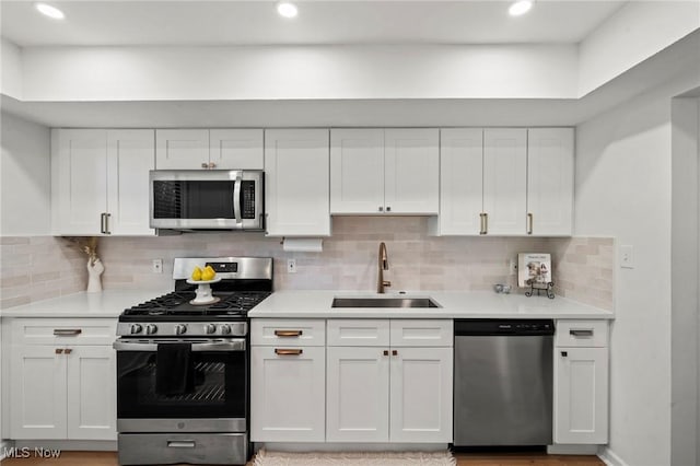 26749 Lake Of The Falls Blvd, Olmsted Falls, OH 44138 - kitchen featuring stainless steel appliances, white cabinets, light countertops, backsplash, and recessed lighting