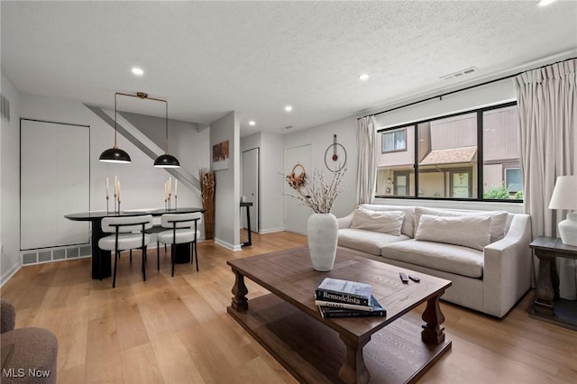 26749 Lake Of The Falls Blvd, Olmsted Falls, OH 44138 - living room with light wood-style flooring, recessed lighting, and a textured ceiling