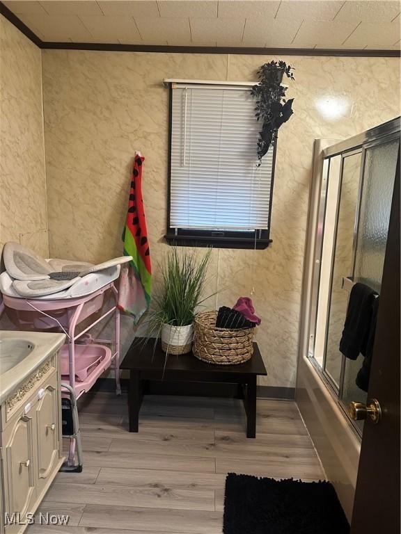 202 Grant St, Newell, WV 26050 - full bathroom with wood finished floors, ornamental molding, vanity, a textured wall, and bath / shower combo with glass door