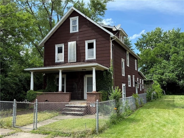 2013 7th St NE, Canton, OH 44704 - american foursquare style home with covered porch, a fenced front yard, and a gate