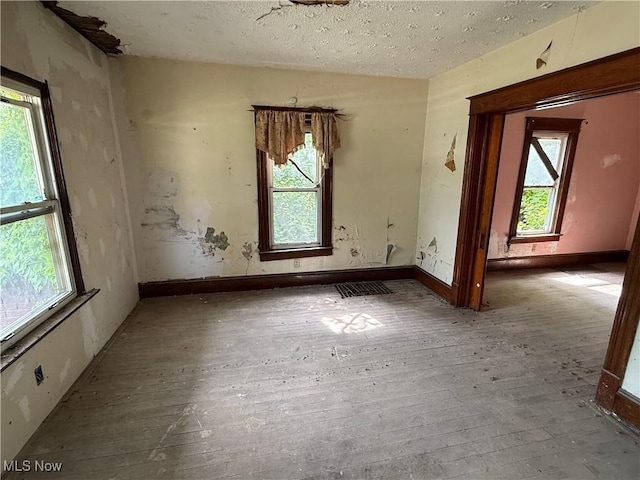 2013 7th St NE, Canton, OH 44704 - spare room featuring hardwood / wood-style floors and a textured ceiling