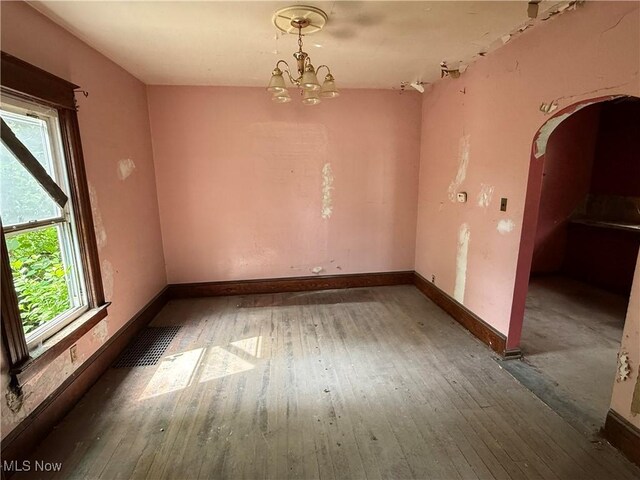 2013 7th St NE, Canton, OH 44704 - unfurnished room with arched walkways, hardwood / wood-style floors, and a chandelier