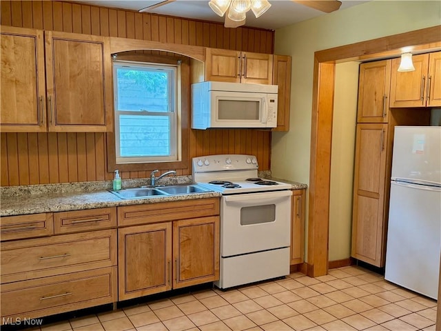 1104 Kenmore Ave SE, Warren, OH 44484 - kitchen with white appliances, light countertops, ceiling fan, light tile patterned floors, and wooden walls