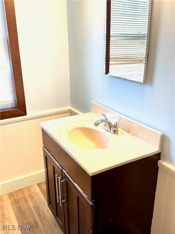 1104 Kenmore Ave SE, Warren, OH 44484 - bathroom with vanity, a wainscoted wall, and wood finished floors