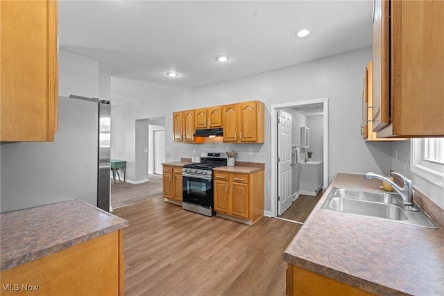 1014 Noble St E, Alliance, OH 44601 - kitchen featuring appliances with stainless steel finishes, under cabinet range hood, wood finished floors, recessed lighting, and brown cabinets