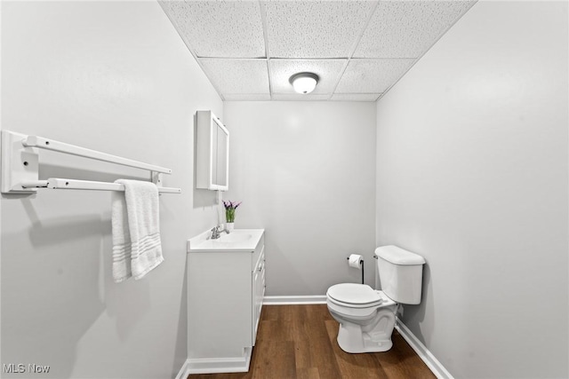 1014 Noble St E, Alliance, OH 44601 - half bathroom featuring a drop ceiling, vanity, and wood finished floors