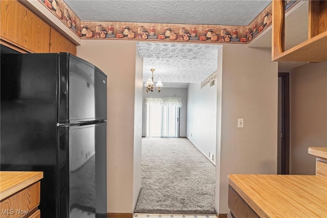3494 Ivy Hill Cir Unit A, Cortland, OH 44410 - kitchen with freestanding refrigerator, a textured ceiling, carpet flooring, a chandelier, and light countertops