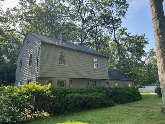 175 Curtis Dr, Avon Lake, OH 44012 - view of side of home with a chimney, a yard, and view of scattered trees