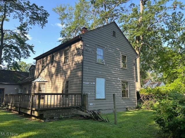 175 Curtis Dr, Avon Lake, OH 44012 - view of side of home featuring a yard, a deck, and a chimney
