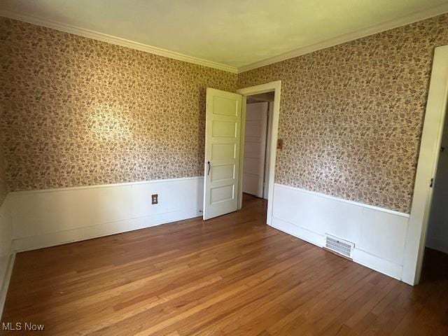 175 Curtis Dr, Avon Lake, OH 44012 - unfurnished room featuring wallpapered walls, wainscoting, ornamental molding, and wood finished floors